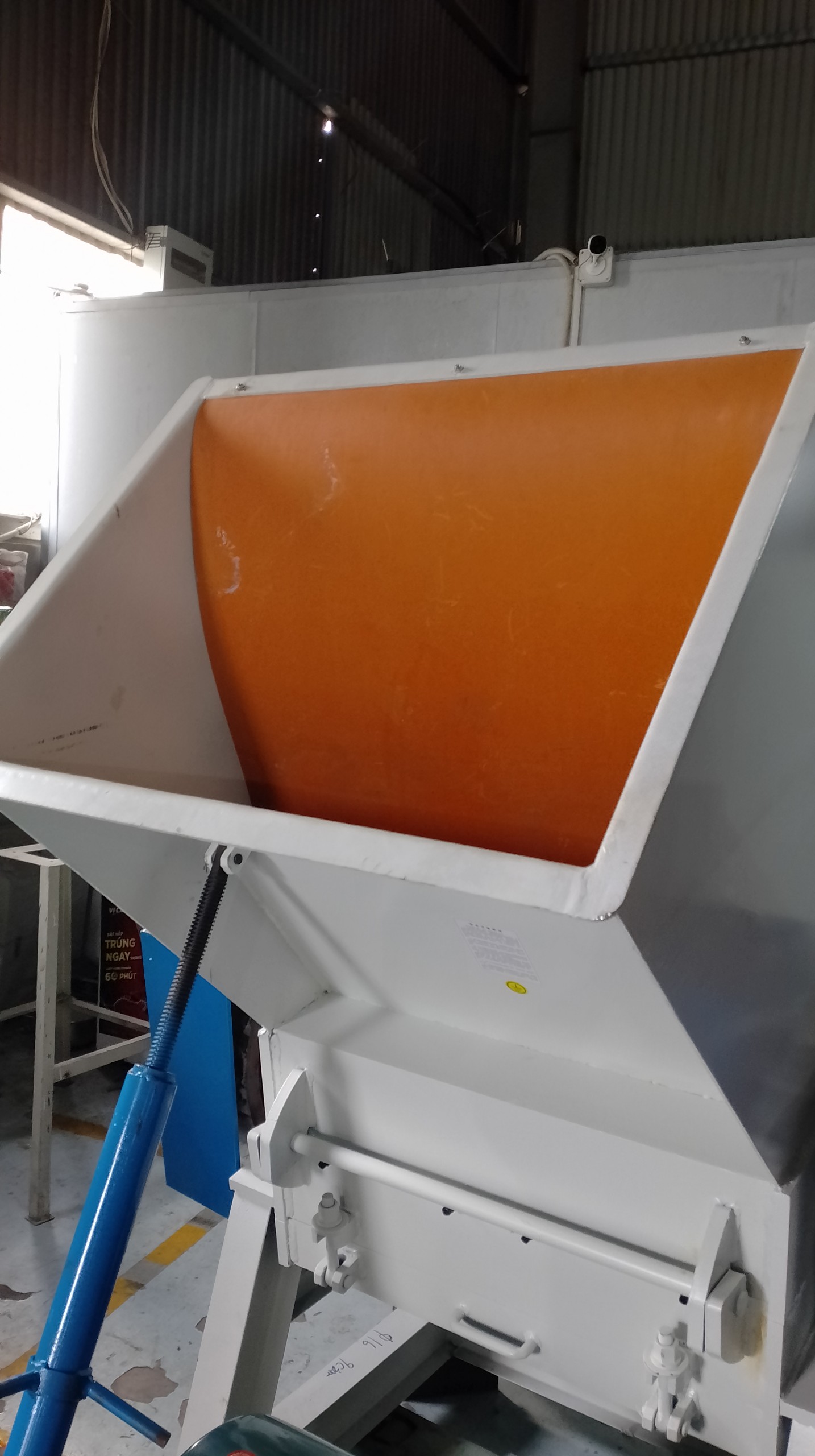 Hình ảnh cửa nhập nguyên liệu cho máy băm nhựa đa năng. Bên dưới là trục vít nâng hạ cửa.